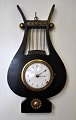 French lyre 
shaped wall 
clock, 19th 
century Empire. 
Black polished 
wood with brass 
decorations. 
...