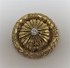 Gold brooch with diamond in 18K gold (750). Diamond ca. 0.20ct. Diameter 25 mm