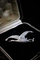 Old brooch in 
silver in the 
shape of a bird 

with lots of 
small shiny 
magazines. 
5x2,5cm.