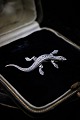 Old brooch in 
silver in the 
form of 
salamanders 
with lots of 
small shiny 
magazines. 
L:5cm.