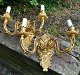 A pair of 
gilded wall 
appliques, 20th 
century France. 
Each with two 
light arms. 
Decorated with 
...