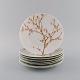 Bjørn Wiinblad for Rosenthal. Eight "Herbst / Autumn" porcelain plates decorated 
with branches and orange leaves. 1970s.
