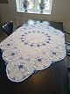 Embroidered tablecloth with blue fluted pattern Measures 127 x 127 cm.
