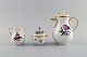 Meissen coffee pot, sugar bowl and cream jug with hand-painted flowers and gold 
decoration. Lids modeled with rosebuds. Early 20th century.

