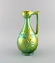 Zsolnay jug in 
glazed ceramics 
modeled with 
foliage. 
Beautiful eosin 
glaze. 1960s.
Measures: 28 
...