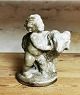 Figur af putti 
med gedebuk fra 
Michael 
Andersen & Søn. 
Fremstår i 
perfekt stand. 
Fabriksmærket 
...