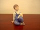Bing & Grøndahl 
has produced 
this cute 
figurine of a 
girl holding 
her doll. It 
has decoration 
...
