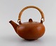 Eva 
Stæhr-Nielsen 
for Saxbo. 
Glazed 
stoneware 
teapot with 
wicker handle. 
Beautiful glaze 
in ...