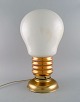 Large table 
lamp in brass 
and opal glass 
shaped like a 
light bulb. 
1960s.
Measures: 49 x 
27 ...