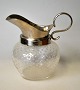 Cream jug, 
approx. 1910. 
Clear glass 
with glass 
bubbles. With 
silver-plated 
spout and 
handle. ...
