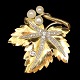 A brooch in 14k 
gold and white 
gold, set with 
three pearls 
and several 
diamonds. Total 
app. 0,98 ...