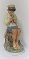Royal Copenhagen. Porcelain figure. Seated boy in colors. Model 905. Height 19 cm. (1 quality)