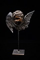 Decorative, antique angel head with face in bronze and wings in copper mounted on a metal foot. ...