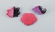 Vallauris, France, three leaf-shaped dishes in brightly colored glazes in shades 
of pink, violet and black.