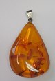 Polished amber 
with seeds, 
with pendant. 
Ca. 5 cm.