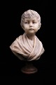 Decorative, old child's bust made of wax on a wooden base with fine patina. Height: 37cm.