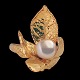 Jean Larsen; 
Ring af 18 kt. 
guld. Blade 
prydet med 
perle.
Ring str. 53. 
Blad l. 2,4 cm. 
...