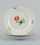 Meissen, Germany. Three porcelain plates hand-painted with various floral motifs 
and gold rim.