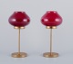 A pair of brass 
tealight 
holders in 
wine-red glass 
shades.
Swedish 
design.
Approximately 
from ...