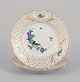 Meissen, Germany. Two open lace plates in porcelain, decorated in gold with an 
exotic bird on a flower branch.