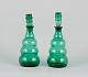 A pair of 
decanters in 
green art glass 
from a Swedish 
...