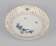 Meissen, Germany. Open lace bowl in porcelain, decorated in gold with an exotic 
bird on a flower branch. Hand-painted.