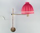 Hans Agne Jakobsson, Swedish designer. Wall lamp in brass with a lampshade in red fabric. ...