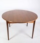 Teak dining table with built-in additional plate and round legs of Danish design from around the ...