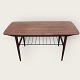 Coffee table in 
teak veneer 
with metal 
newspaper shelf 
and bast 
mounting at the 
ends. Appears 
in ...