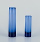 Per Lütken for 
Holmegaard, 
Denmark.
Two 
cylindrical art 
glass vases in 
blue ...
