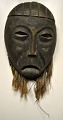 African mask, mid 20th century. Carved wood with jute. H.: 40 cm.Provenance: Globetrotter, ...