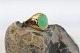 This beautiful lady's ring is forged in solid 14 carat gold, and topped with a beautiful green ...