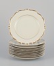 KP, Karlskrona, Sweden. A set of ten cream-colored porcelain plates with gold 
decoration.