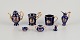 Limoges, France. Seven pieces of miniature porcelain, decorated with 22-karat 
gold leaf and a beautiful royal blue glaze. Scène galante.