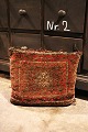 Old decorative pillows made from antique Persian carpets on the front and old kilim carpet on ...