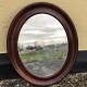 Older mirror in mahogany veneered frame. Heavy patination on the mirror glass. 59x48 cm