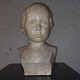 Bust of boy's head in patinated plaster. Done by an unknown artist who signed the bust with B. ...