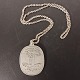 Ellipse-shaped 
pendant in 
pewter designed 
by Jørgen 
Jensen, with 
Piet Hein gruk: 
"En smule dy' - 
...
