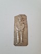 Votive in 
silver with 
motif of a boy 
Stamped 800
Dimension 3.5 
x 8 cm.