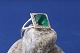Elegant lady's 
ring with a 
beautifully 
faceted green 
stone, 
surrounded by a 
border with 
clear ...