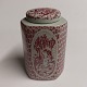 Triangular tea 
caddy  with lid 
in faiance from 
the Nymølle 
factory. Red 
decorated with 
a naked ...