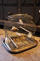 Decorative, 
antique 19th 
century French 
metal birdcage 
on a brass tray 
with 2 feeding 
troughs in ...