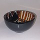 Faience bowl 
from Royal 
Copenhagen. 
Colorful 
decoration 
inside. black 
on the outside. 
...