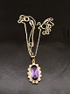 14 carat gold 
pendant 2.5 x 
1.4 cm. with 
amethyst 
surrounded by 
clear stones 
and 14 carat 
gold ...