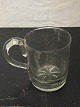 Stort ølkrus i 
glas. Riflet 
bundparti og 
påsat hank. 
Tilskrives 
Holmegaard 
Glasværk fra 
midten ...