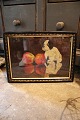 Decorative, old 
oil painting 
with a motif of 
a small dog 
sitting on a 
table with 2 
apples. The ...
