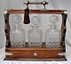 English 
tantalus with 
three crystal 
decanters, 19th 
century. 
Polished oak. 
With 
silver-plated 
...