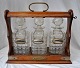 English 
tantalus with 
three crystal 
decanters, 19th 
century. 
Polished oak. 
With brass 
fittings ...