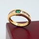 Ring in 18k 
gold set with 
diamonds and 
emerald
