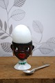 Old egg cup from the 1930s in porcelain with a painted funny face. Height: 6.5cm.